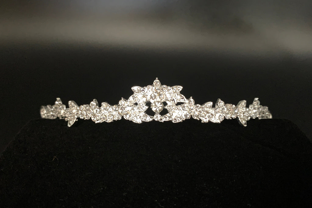 silbernes-diadem-mit-kristallblüten-auf-braunem-hintergrund-und-dekosteinen