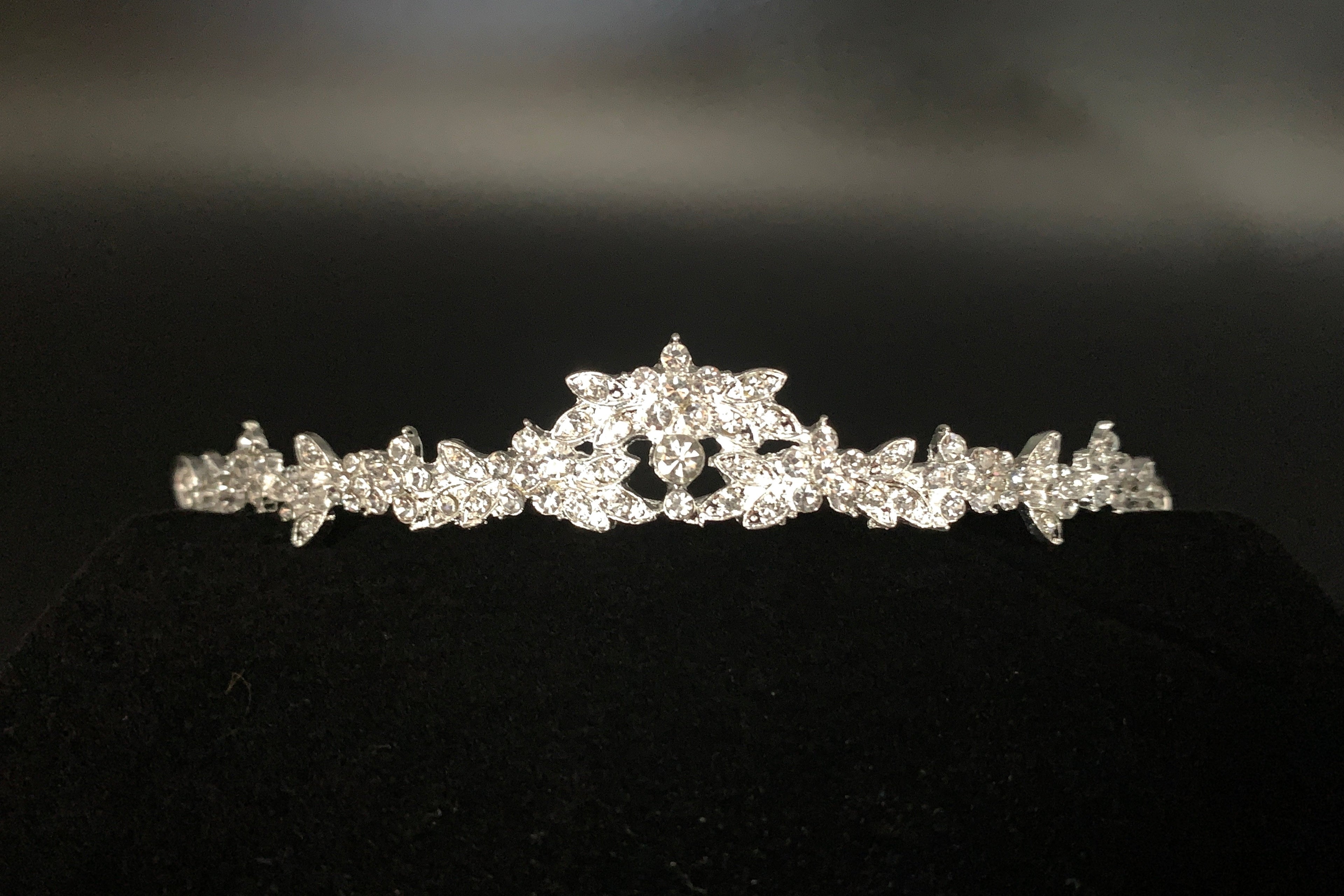 silbernes-diadem-mit-kristallblüten-auf-braunem-hintergrund-und-dekosteinen