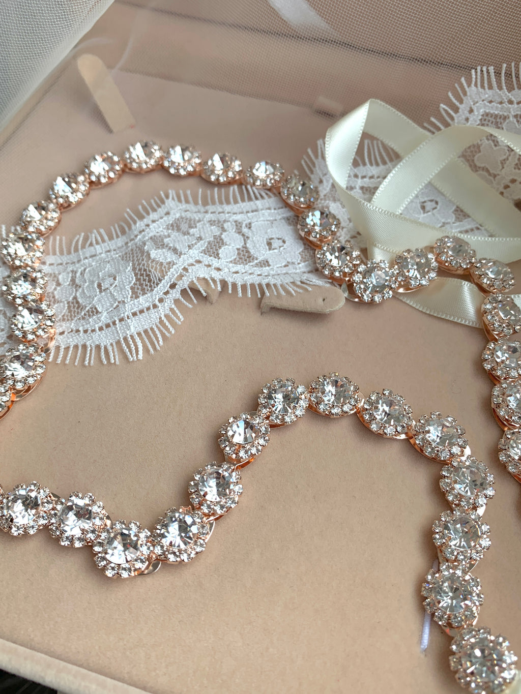 detailaufnahme-brautguertel-mit-runden-kristallen-rosegoldfarben-auf-spitze-und-tuell