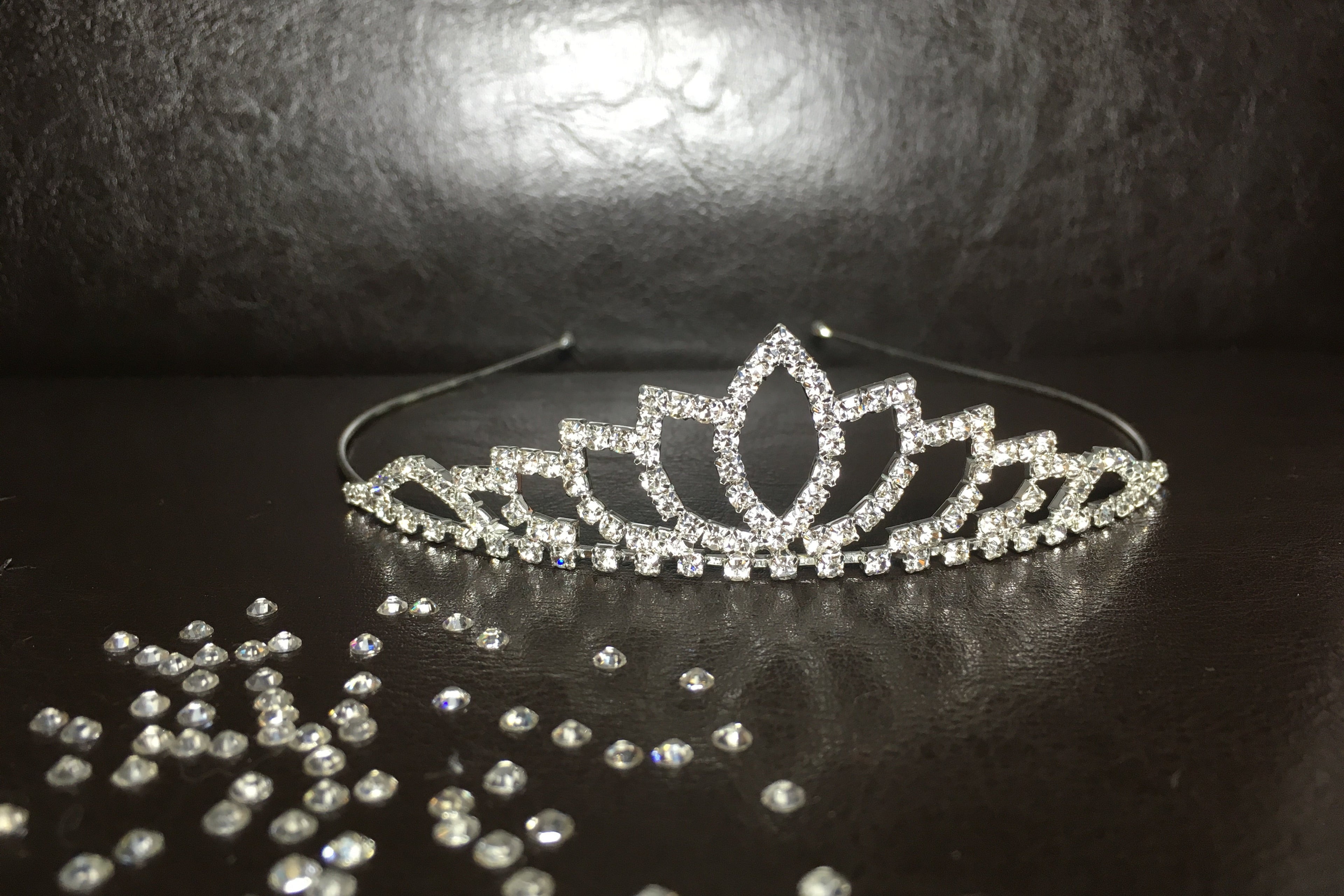 diadem-silber-strasssteine-lotus-design-hochzeit-tiara-mit-deko-steinen-auf-dunklem-hintergrund