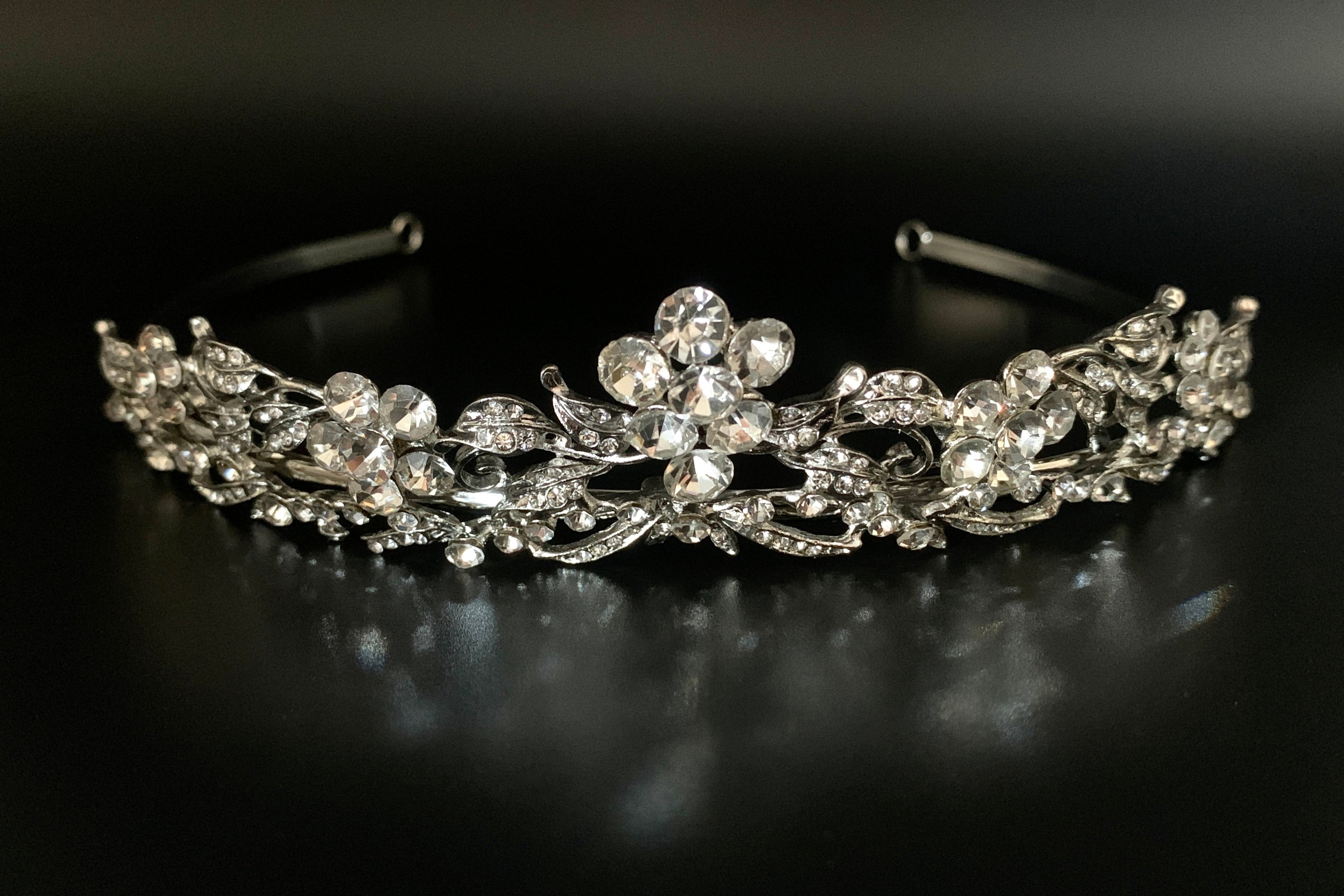 glitzerndes-silbernes-brautdiadem-mit-kristallblüten-auf-schwarzem-hintergrund