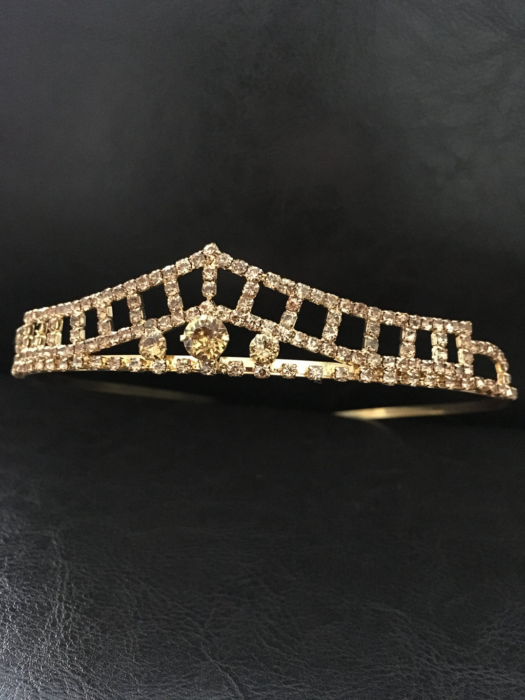 goldenes-diadem-mit-zirkonia-und-mittelstein-frontale-aufnahme-auf-schwarzem-hintergrund