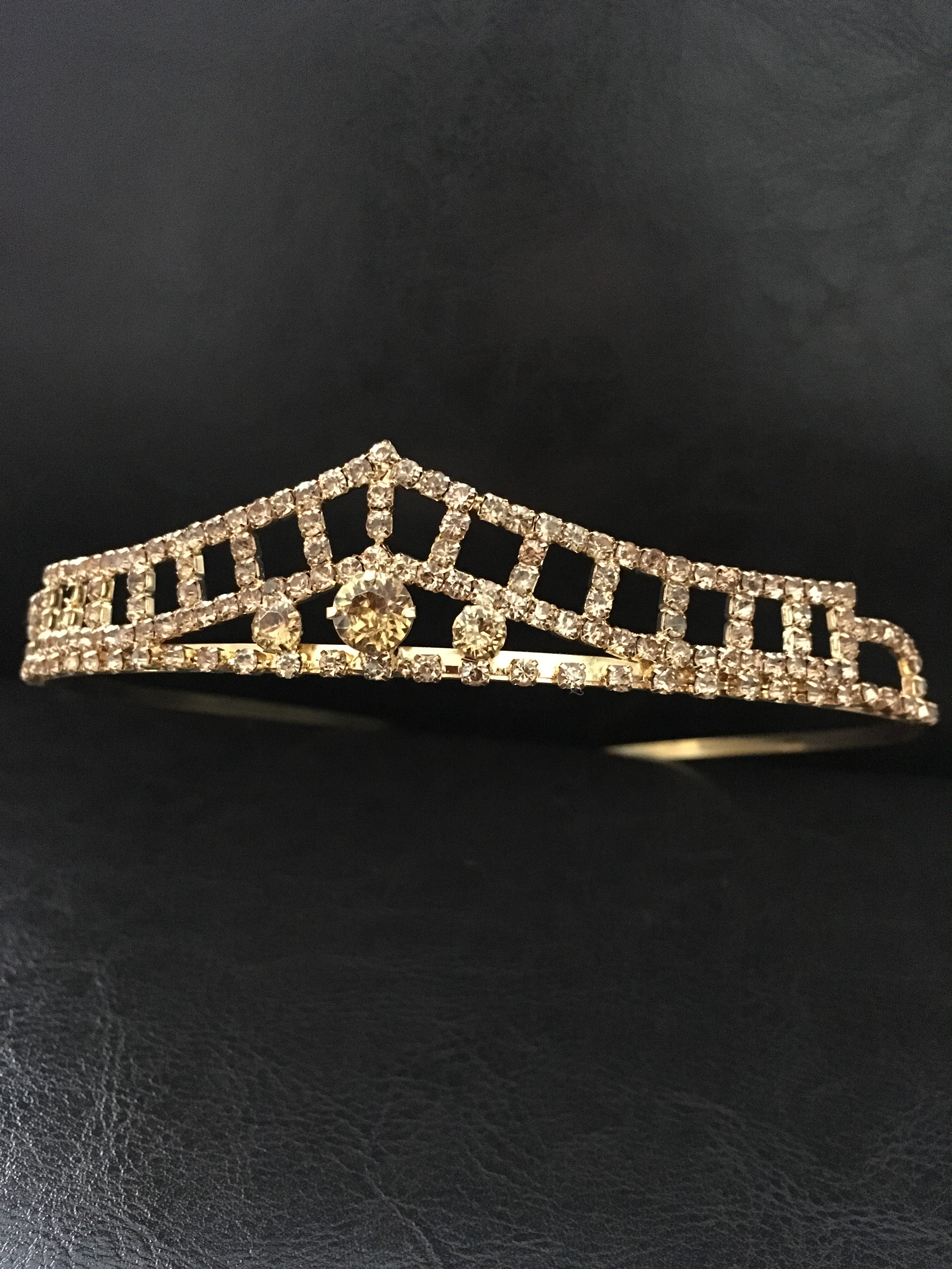 goldenes-diadem-mit-zirkonia-und-mittelstein-frontale-aufnahme-auf-schwarzem-hintergrund