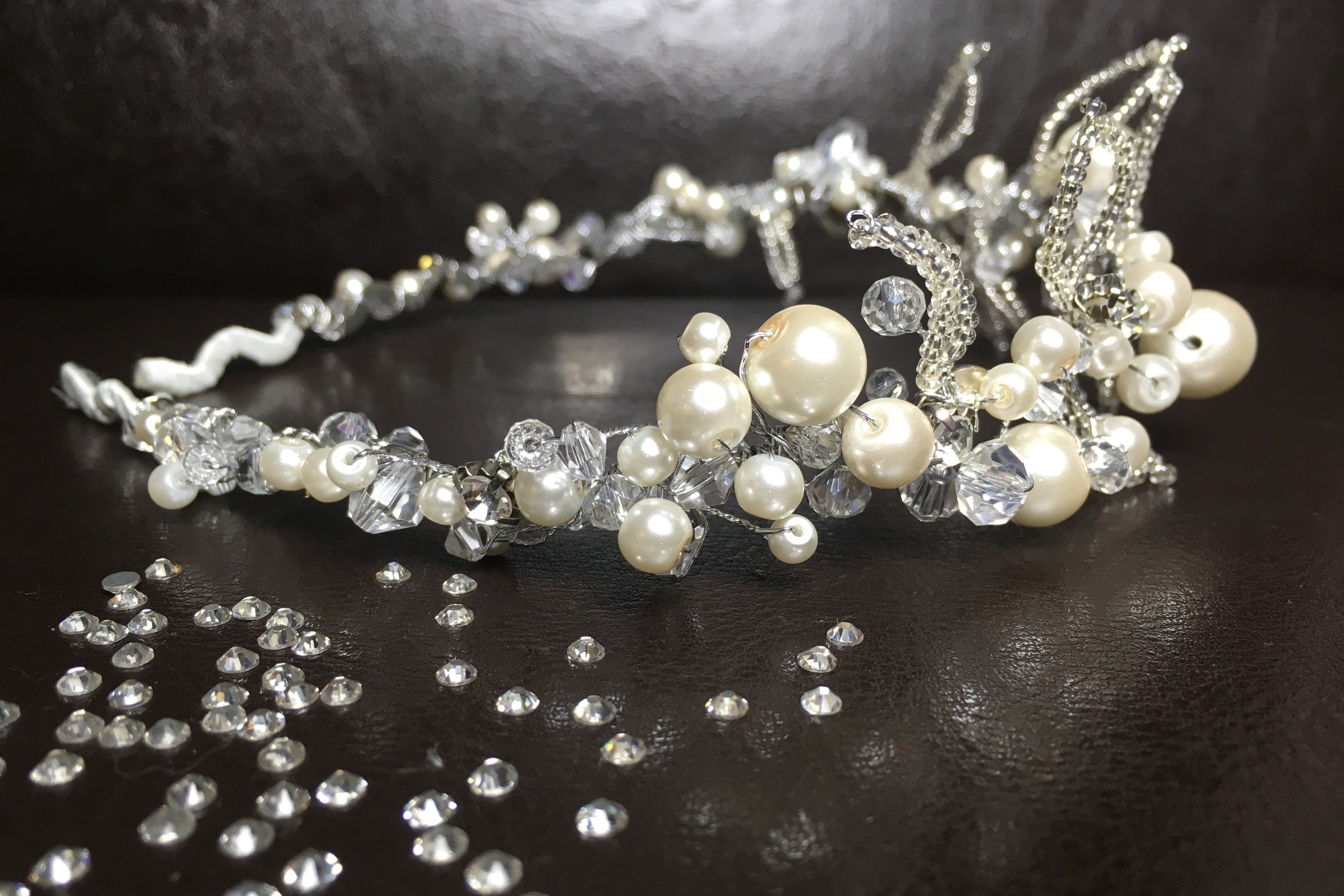 handgefertigte-perlenkrone-mit-kristallen-und-glitzersteinen-auf-dunklem-hintergrund