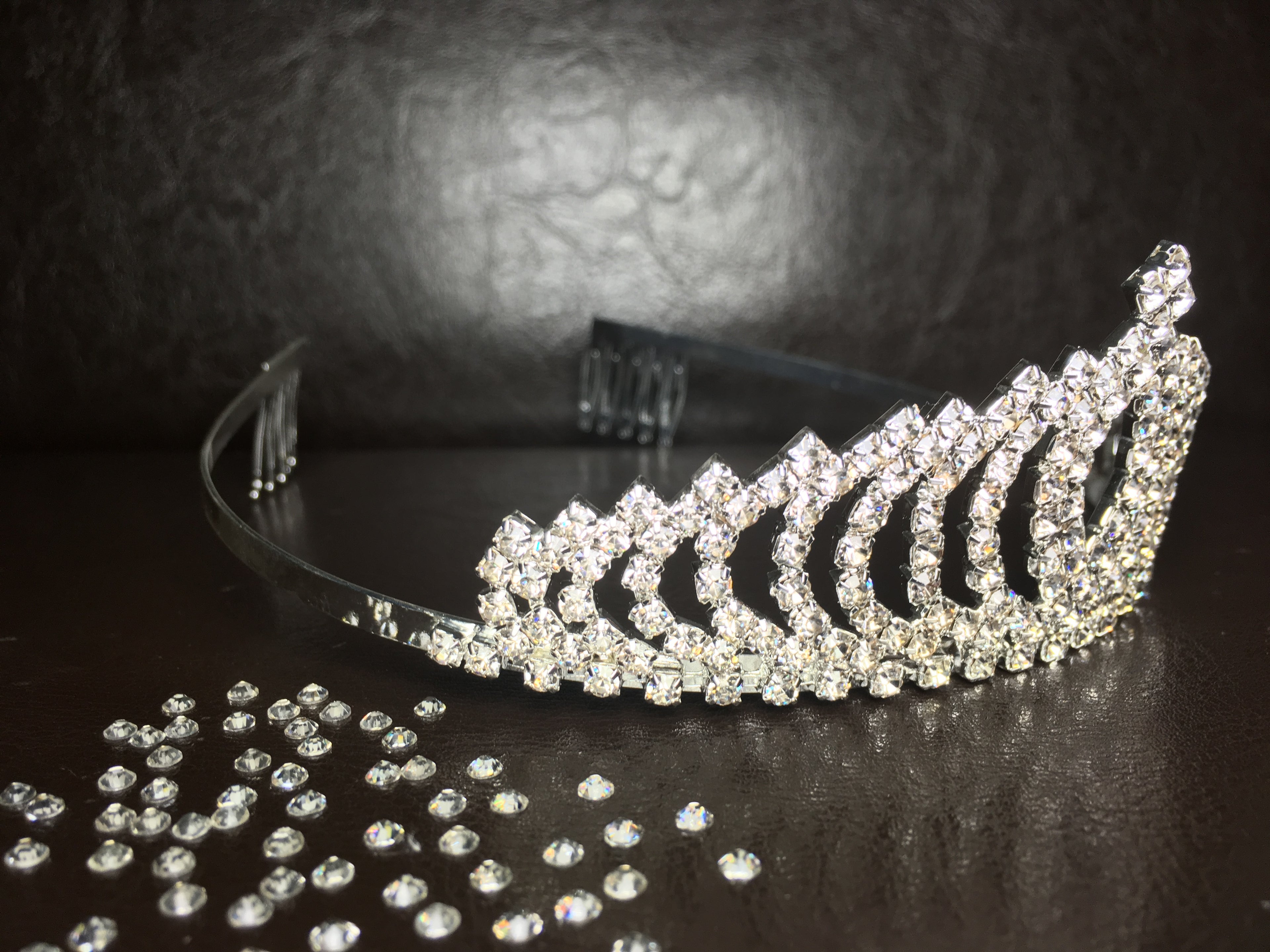 kristallbesetzte-tiara-in-fächerform-auf-lederuntergrund-mit-kristallstreuung