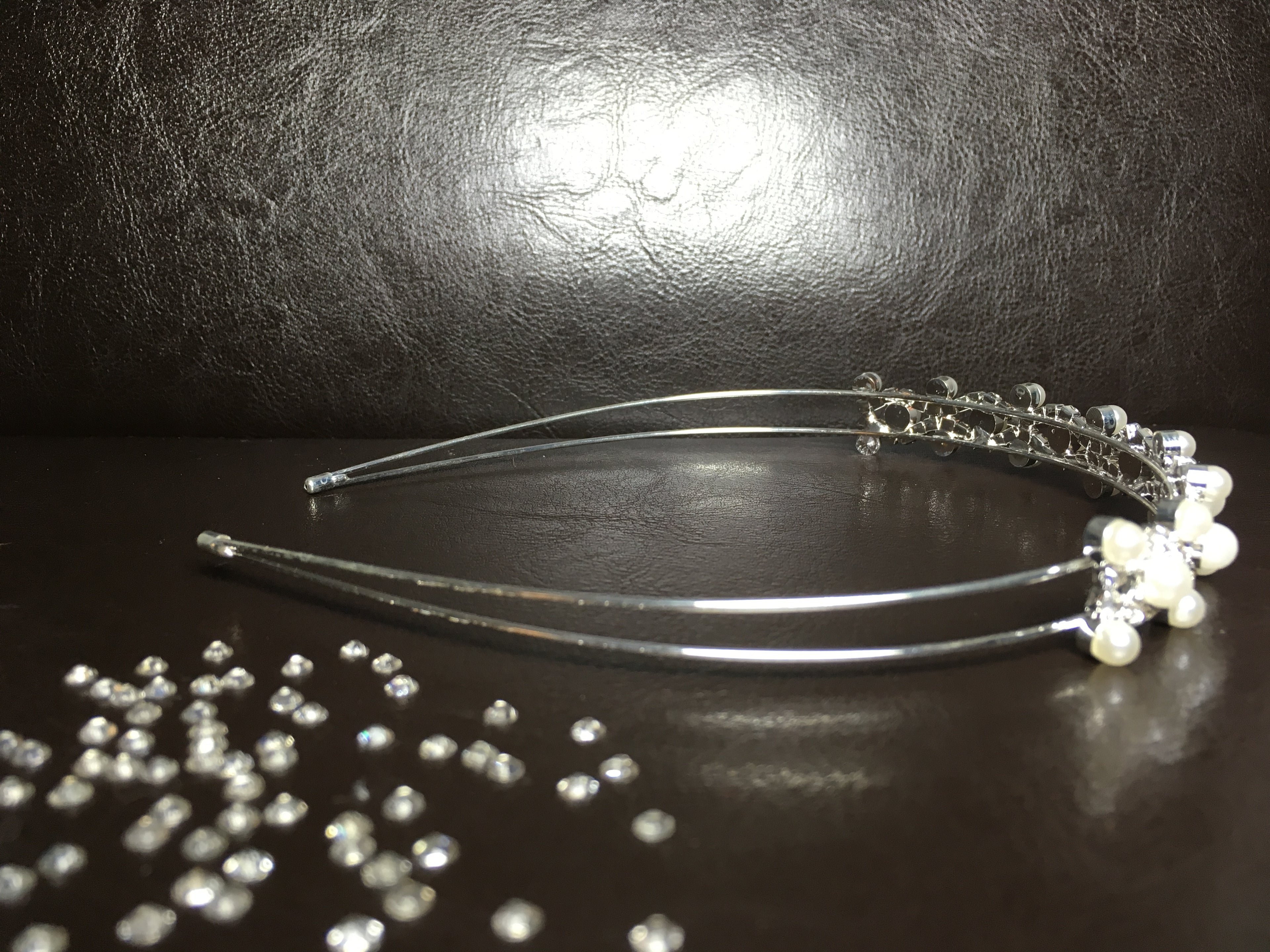 ondego-perlen-diadem-braut-haarreif-wellenform-seitlich-auf-braunem-hintergrund