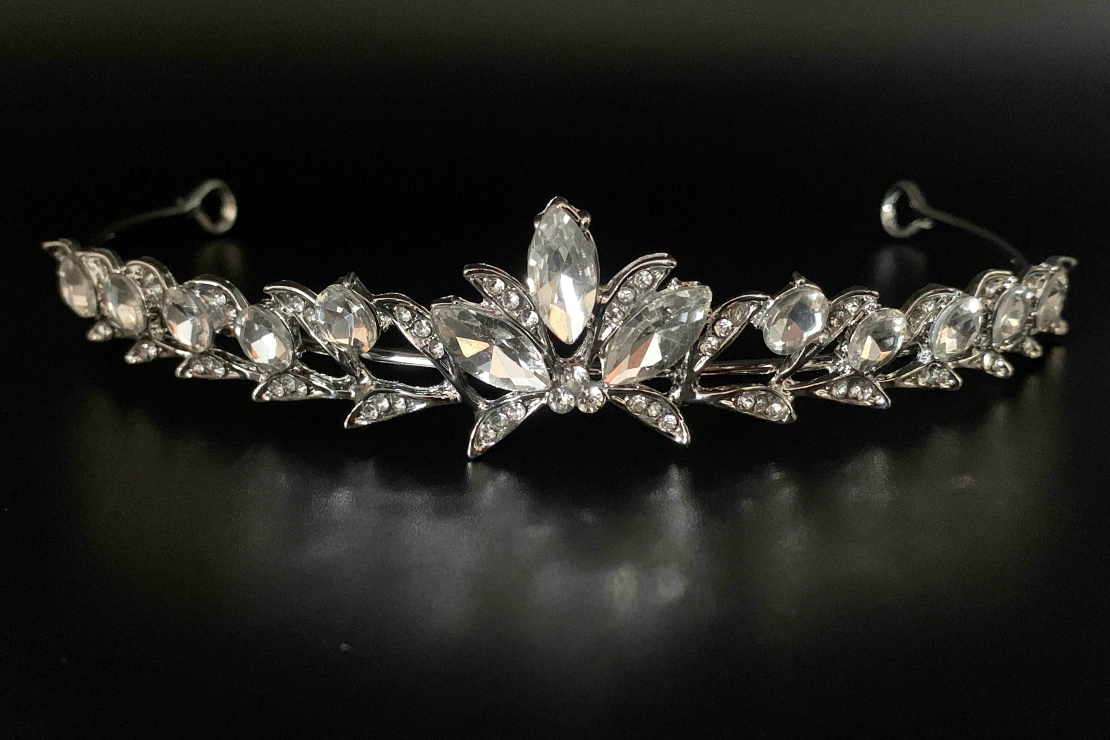 silbernes-diadem-mit-großen-kristallen-und-blütenform-auf-schwarzem-hintergrund