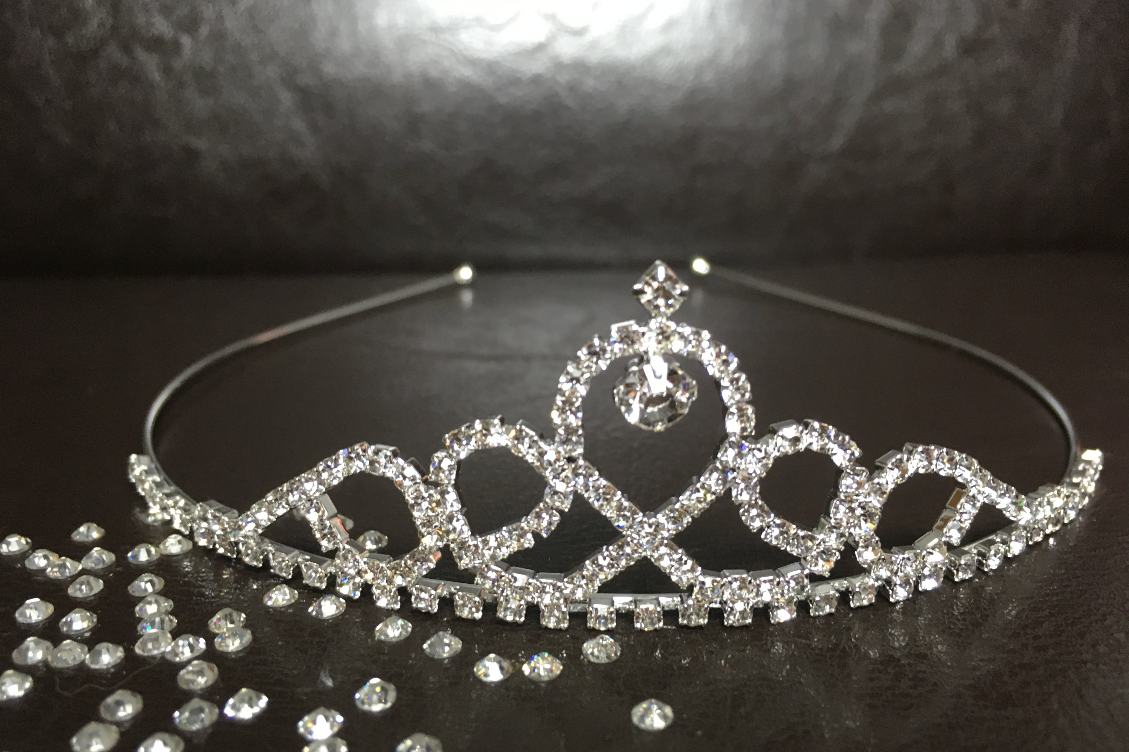 silbernes-diadem-mit-herzförmigem-strassdesign-auf-braunem-hintergrund-mit-kristallsteinchen
