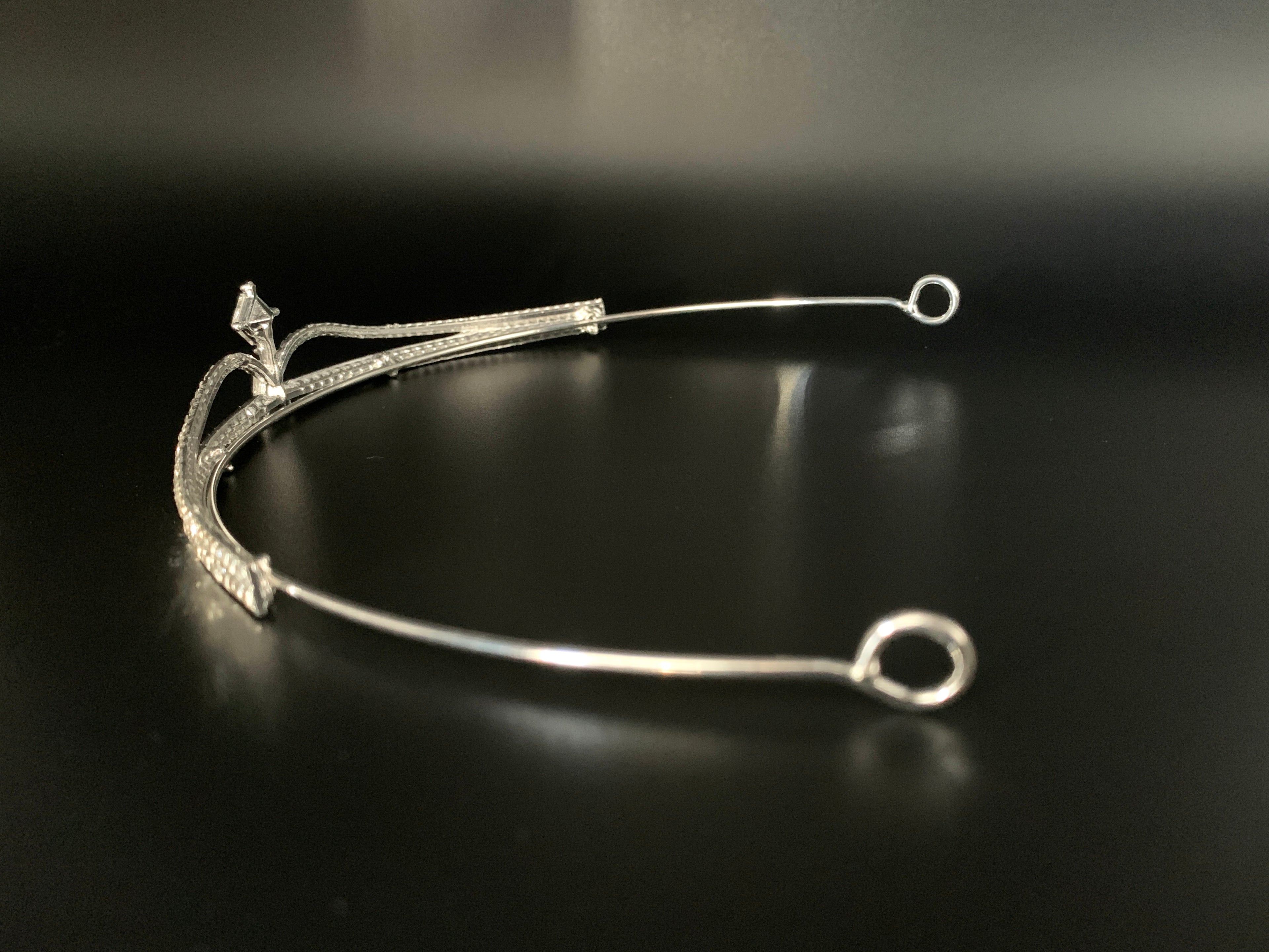 tiara-diadem-silber-zweireihig-mit-kristallstein-detailansicht-seitlicher-metallbuegel-und-zierstruktur-auf-schwarzem-hintergrund