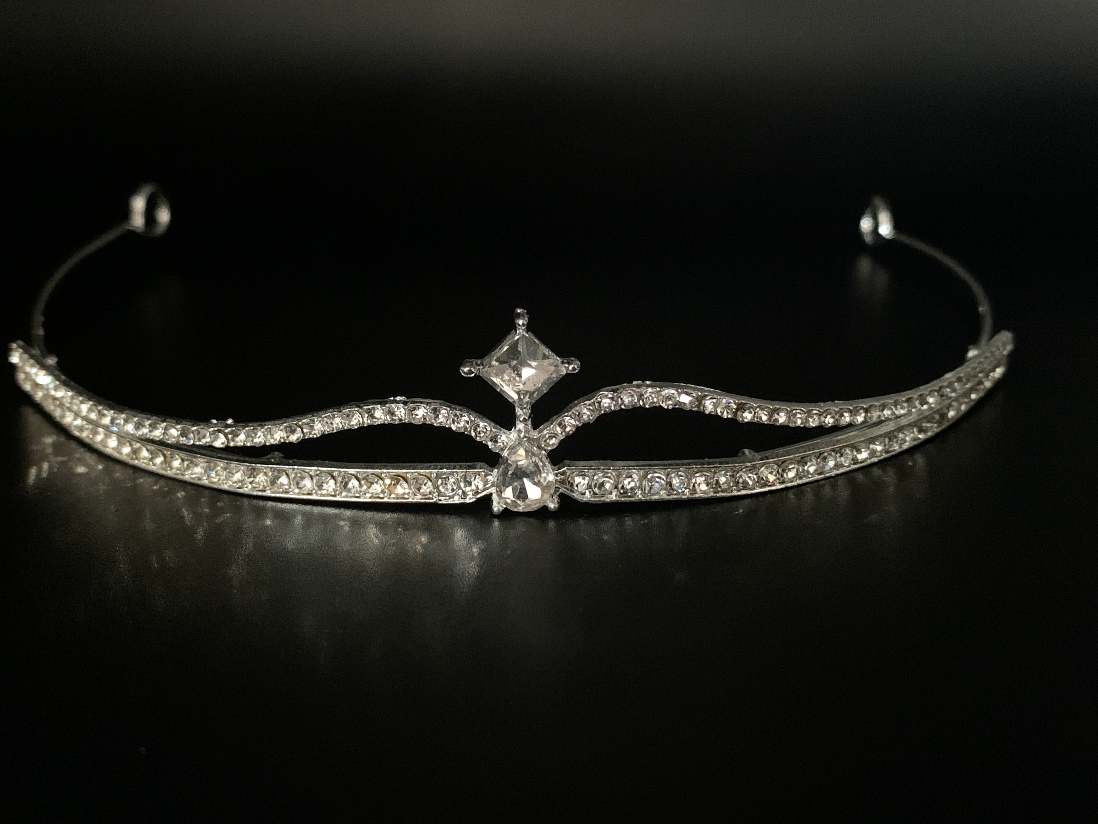 tiara-diadem-silber-zweireihig-mit-kristallstein-mittelpunkt-frontale-nahaufnahme-auf-schwarzem-hintergrund
